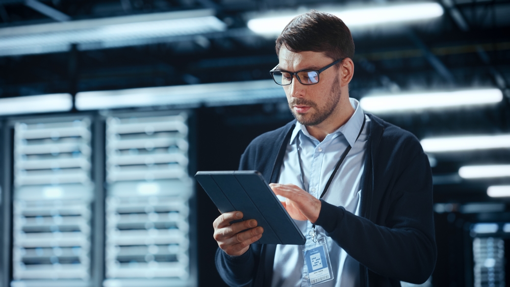 Male,It,Specialist,Walks,Between,Row,Of,Operational,Server,Racks
